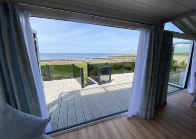 Lodge bifold doors open to balcony with sea view - West Point Beach Resort