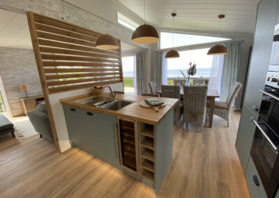 Lodge kitchen with wooden slat partition and breakfast bar - West Point Beach Resort