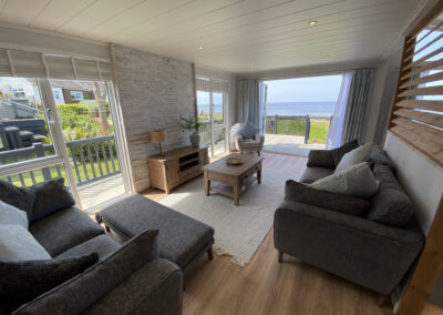 Lodge lounge with grey sofas and balcony sea view - West Point Beach Resort